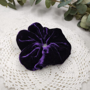 Klassisk scrunchie sydd av lilla silke.