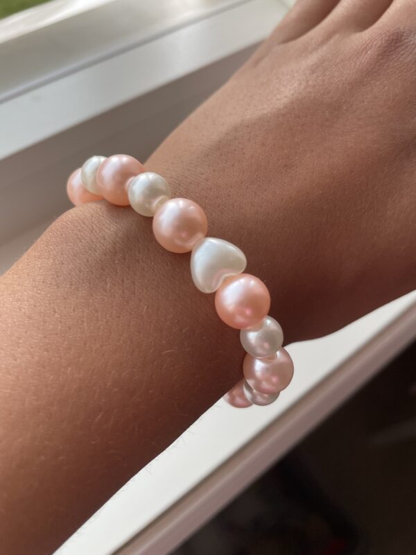 Hvit og rosa perle armbånd med en hjerte charm🩷🤍